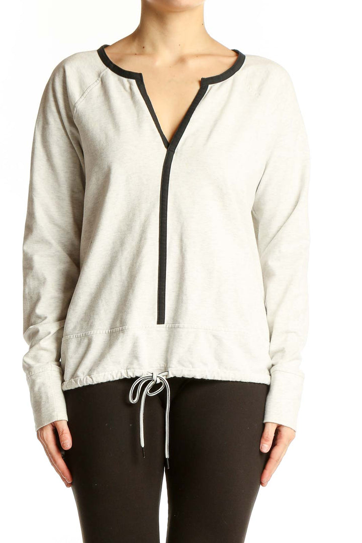Front view of white Athleta athletic top with V-neck and black trim