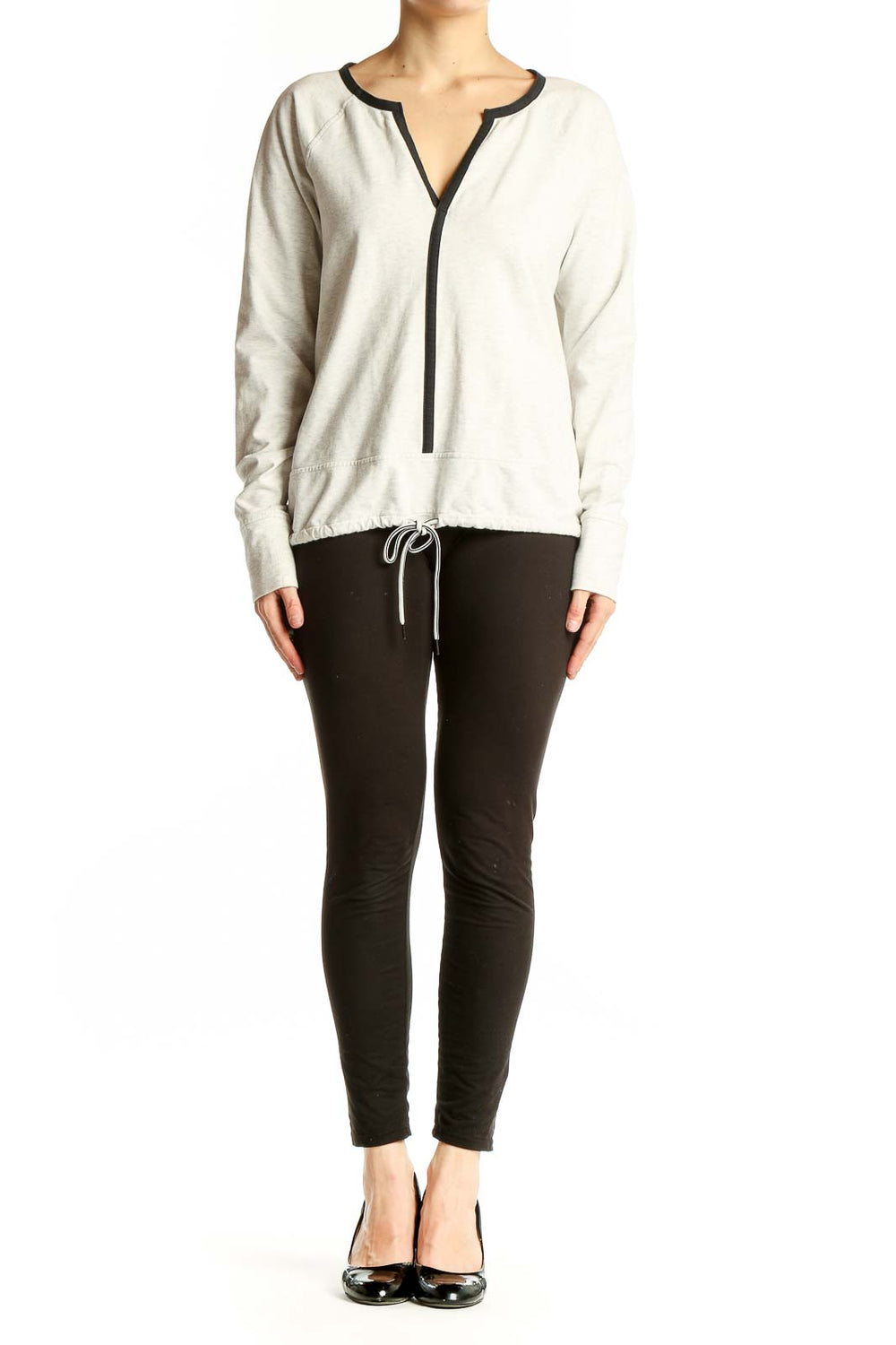 Front view of white Athleta athletic top with V-neck and black trim