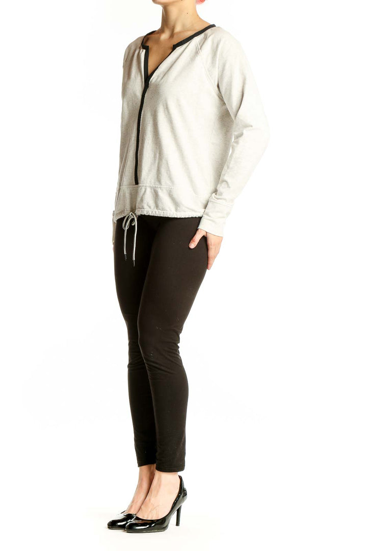 Front view of white Athleta athletic top with V-neck and black trim