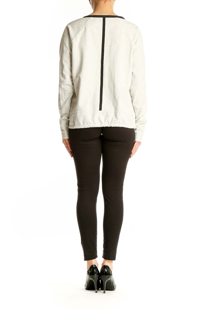 Side view of white Athleta athletic top showing drawstring hem