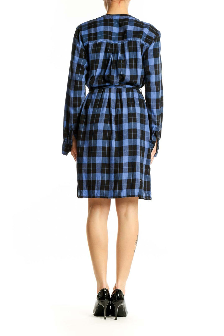 Side view of blue and black plaid Gap shirt dress showing long sleeves and knee-length cut