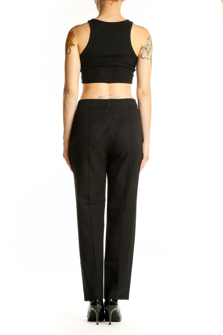 Side view of model wearing Sonia Rykiel black wool trousers with black top