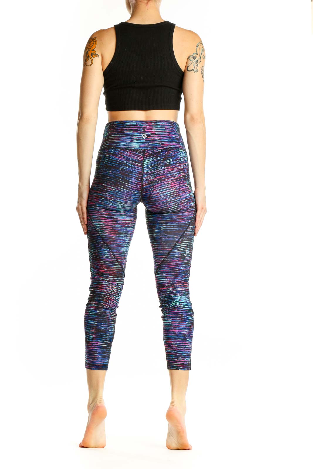 Side view of woman wearing Athleta multicolor space-dye cropped leggings and black crop top