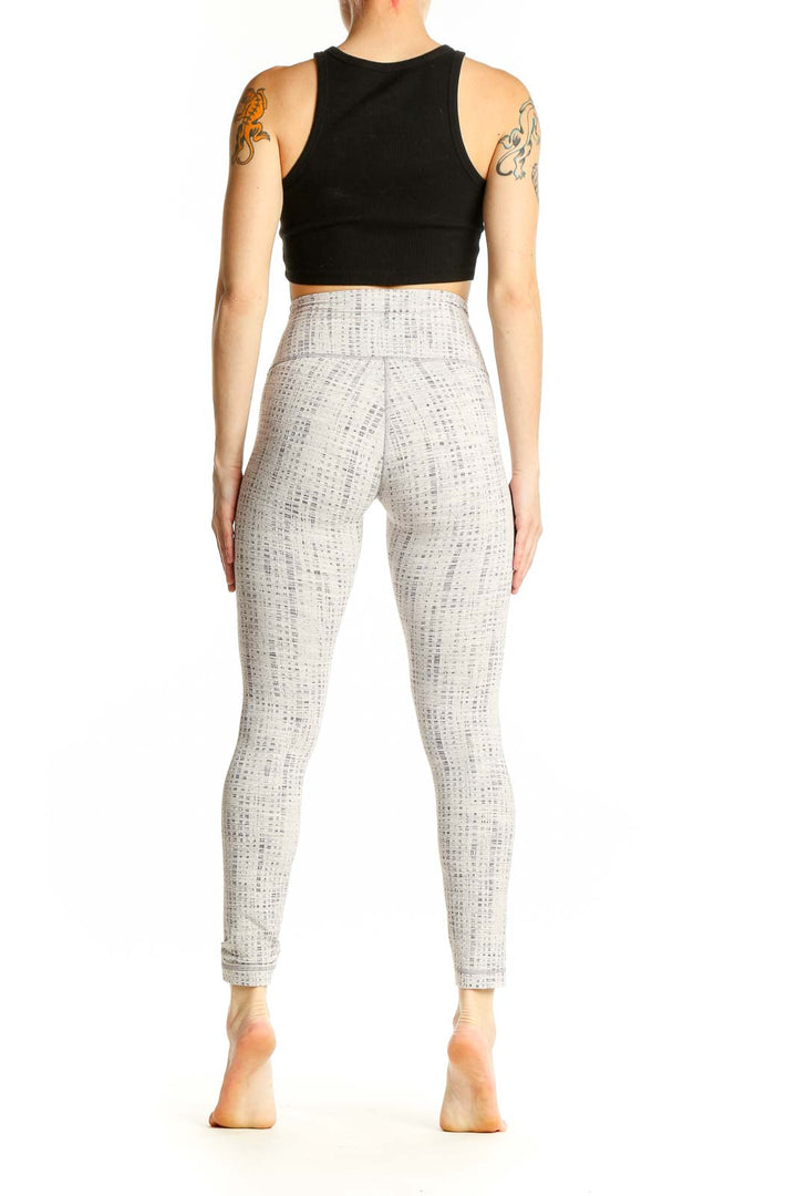 Side view of white textured Lululemon high-waist yoga leggings with black crop top