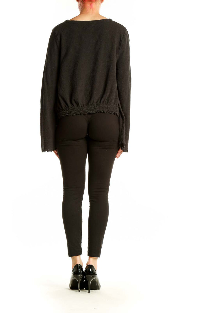 Back view of Madewell black cotton cropped long sleeve top on model