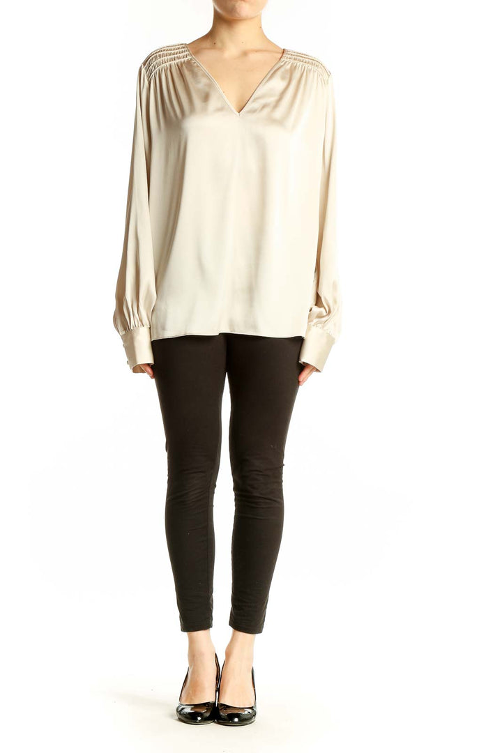 Front view of cream V-neck blouse with gathered shoulders