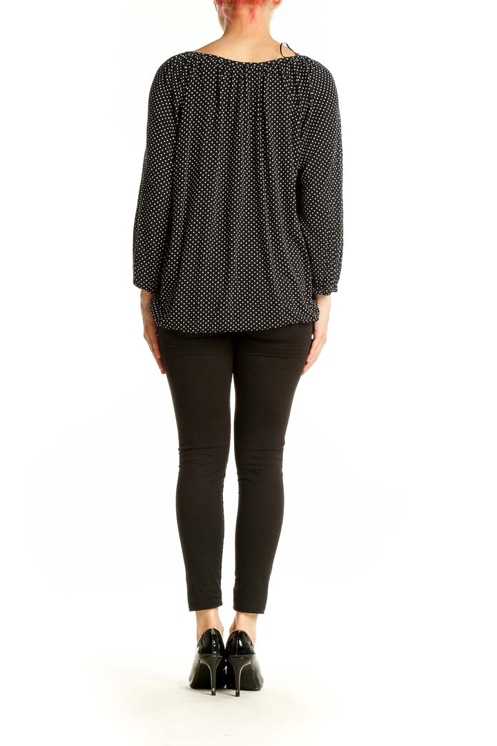 Side view of MICHAEL Michael Kors black polka dot blouse showing relaxed fit