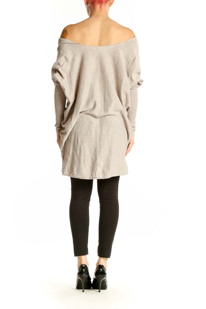 Side view of All Saints beige off-shoulder asymmetric knit sweater on model
