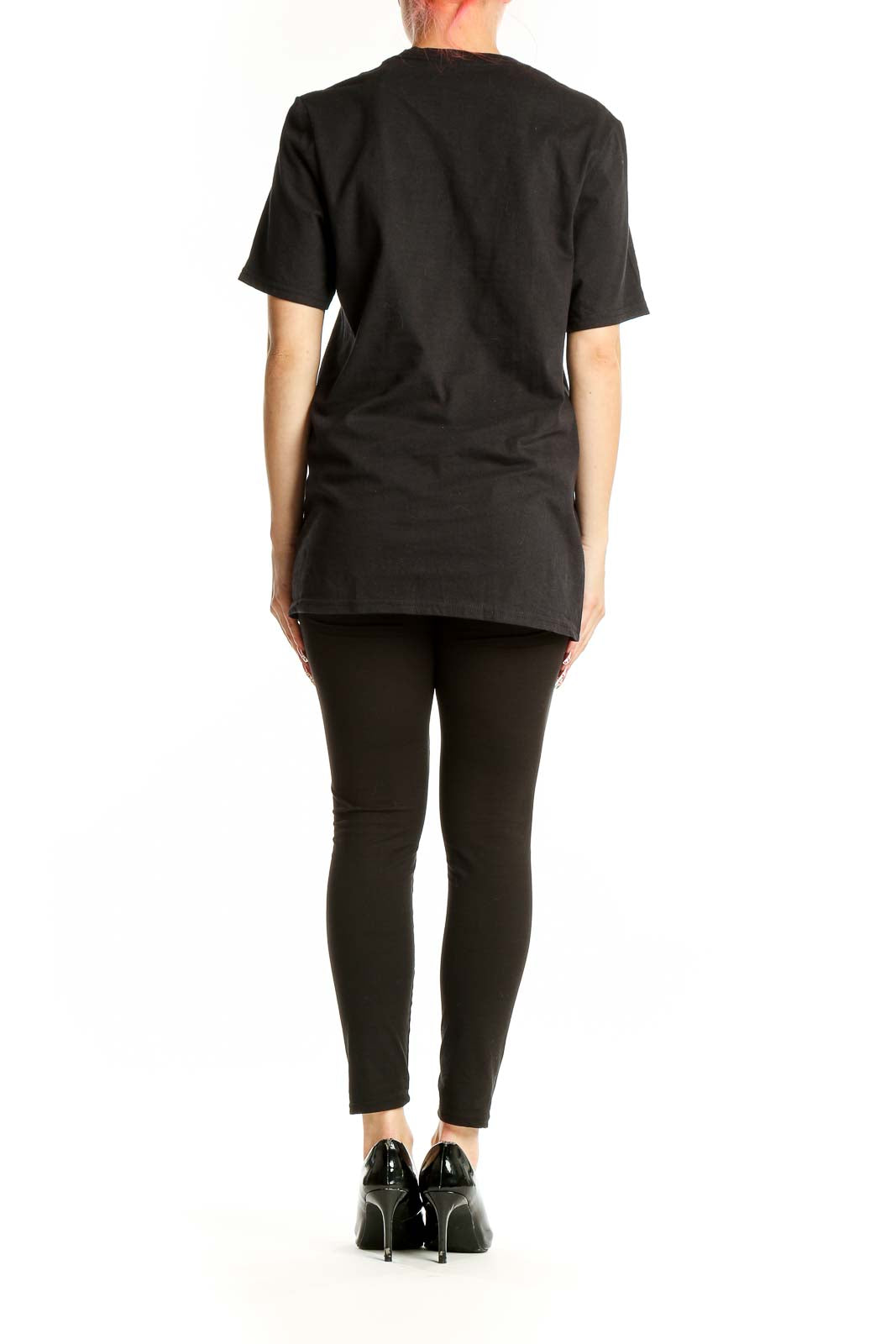 Side view of woman wearing black Adidas logo t-shirt with black pants