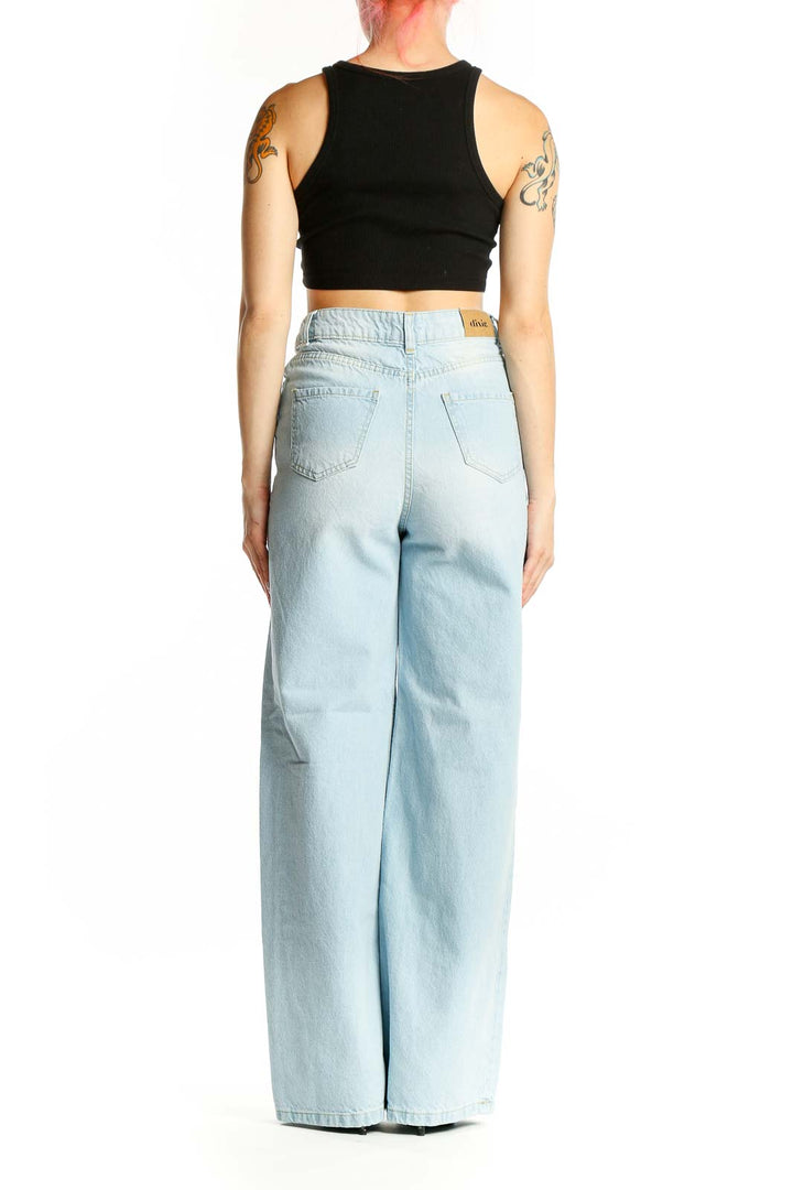 Side view of Dixie light blue wide-leg jeans on model with black crop top