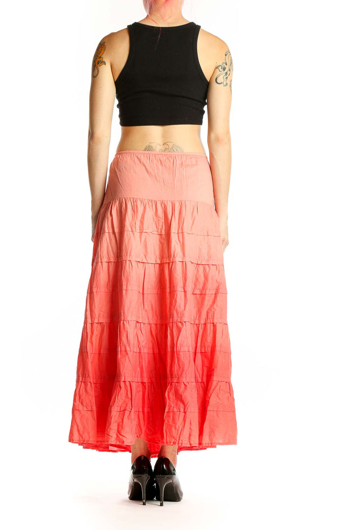 Side view of model wearing Jones New York coral tiered cotton maxi skirt with black crop top