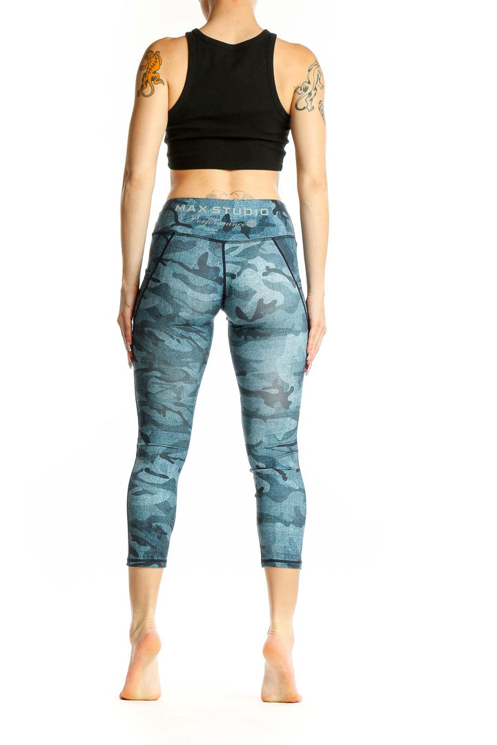 Side view of woman wearing blue camo print capri leggings and black crop top