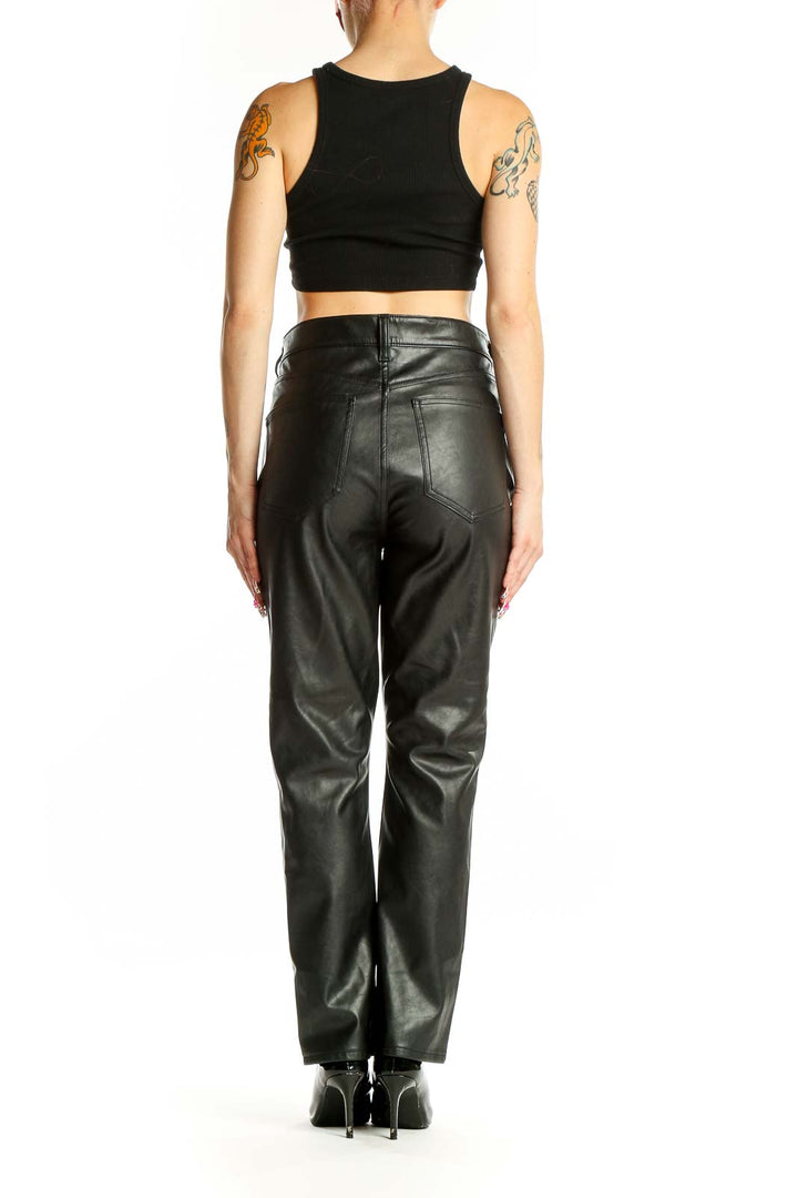 Side view of woman wearing Gap black faux leather pants with black crop top