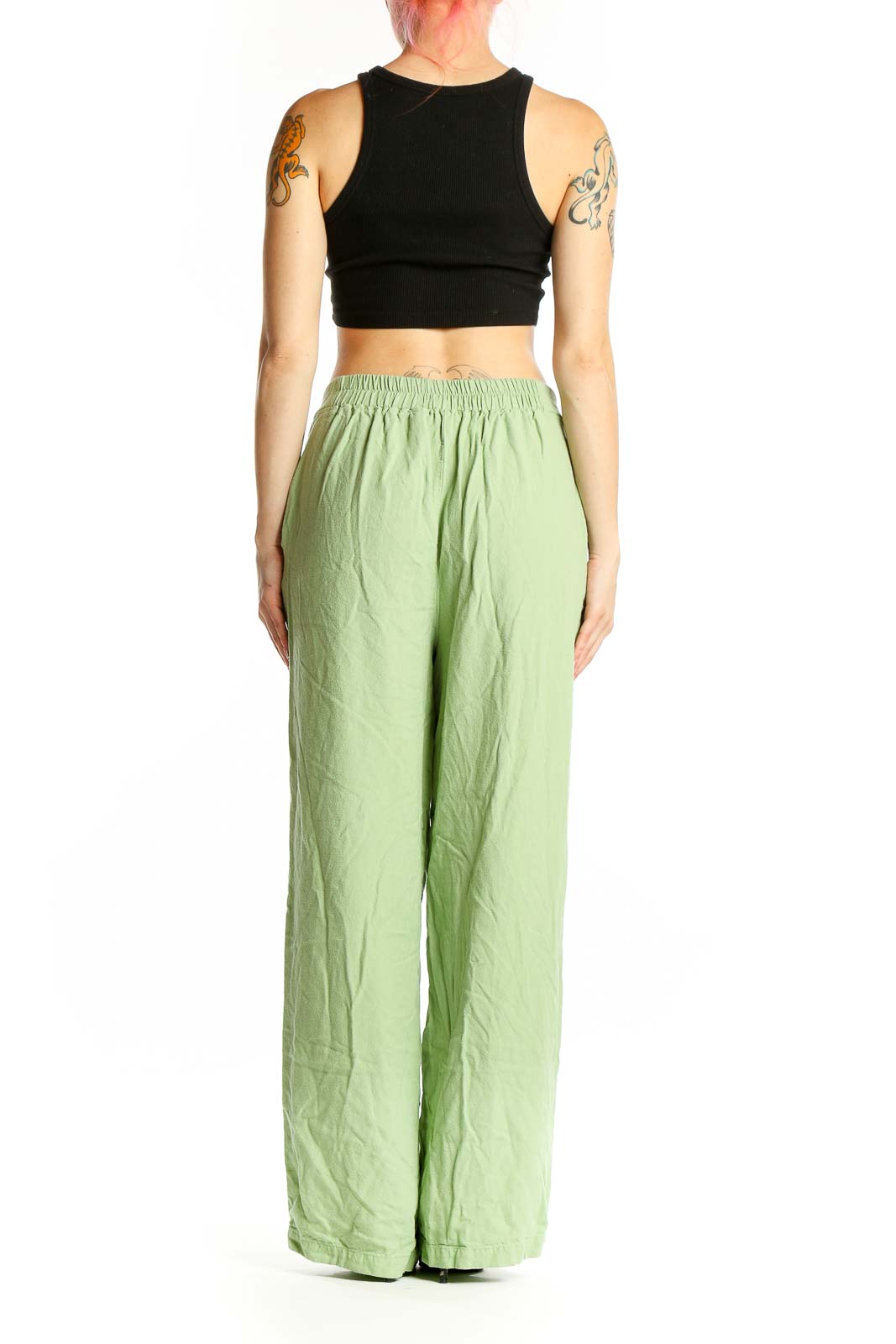 Side view of model wearing Vero Moda light green wide-leg pants with black crop top