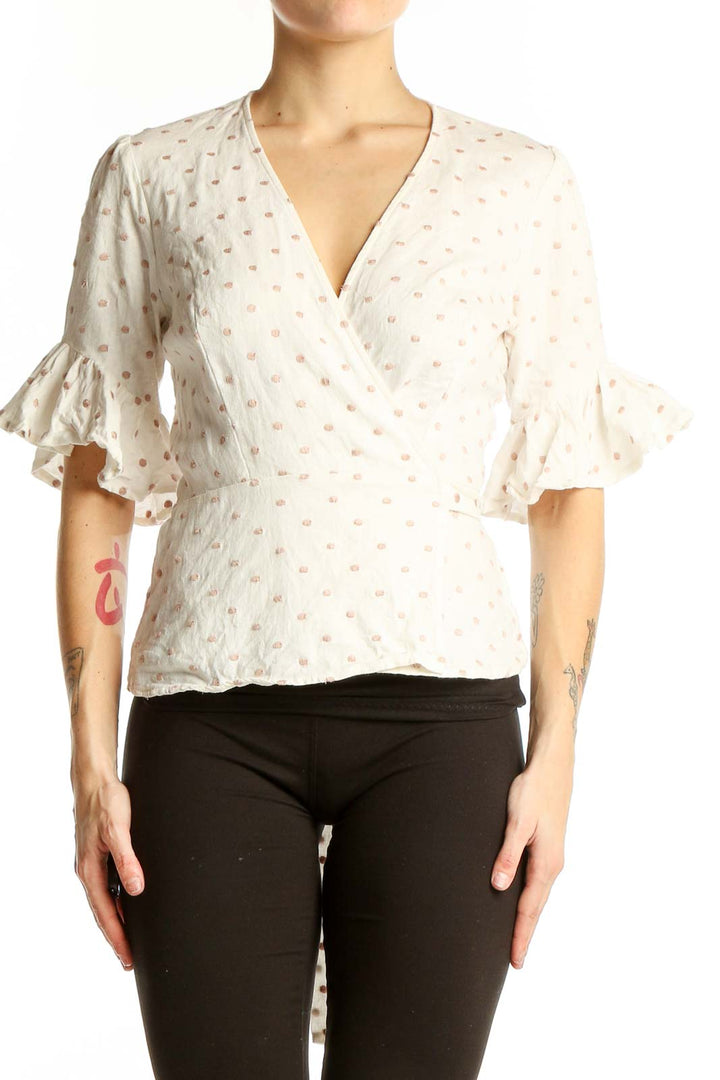Front view of Wayf white polka dot wrap top with ruffle sleeves