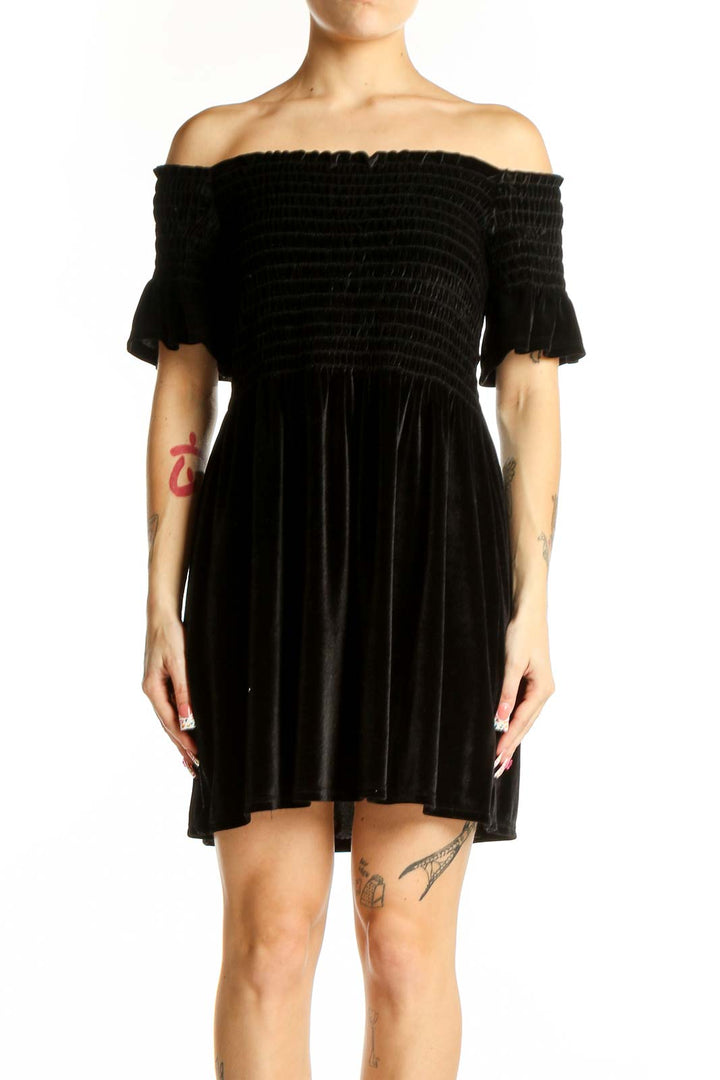 Front view of black velvet off-shoulder mini dress with smocked bodice