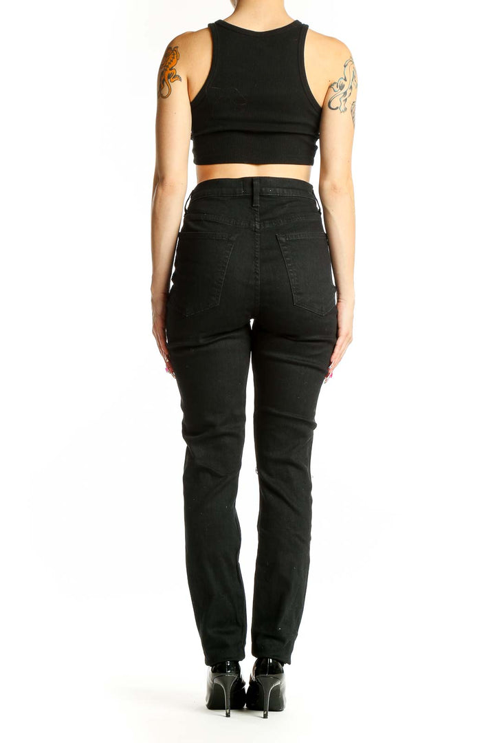 Side view of woman wearing Reformation black high-waisted straight leg jeans