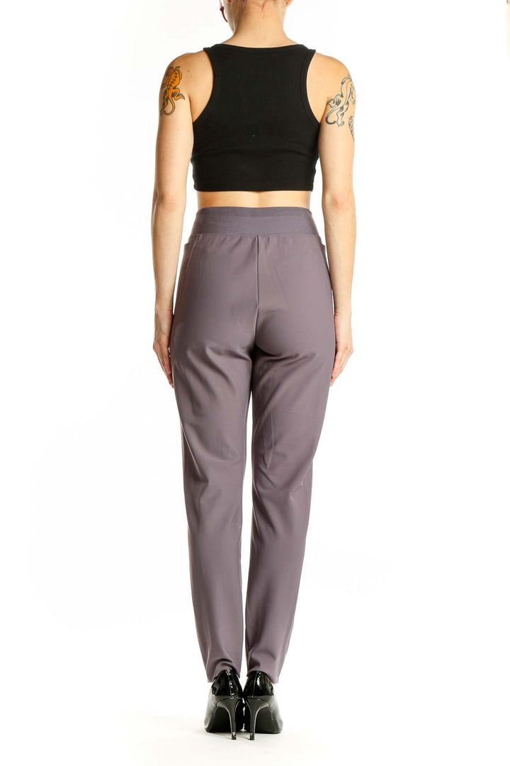 Side view of woman wearing gray Athleta high-waisted performance pants with black crop top