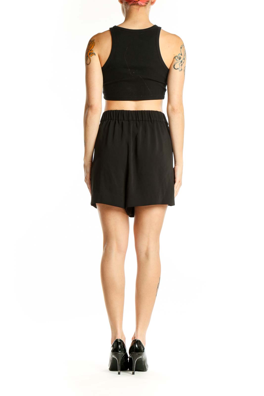 Side view of woman wearing black Calvin Klein shorts with crop top