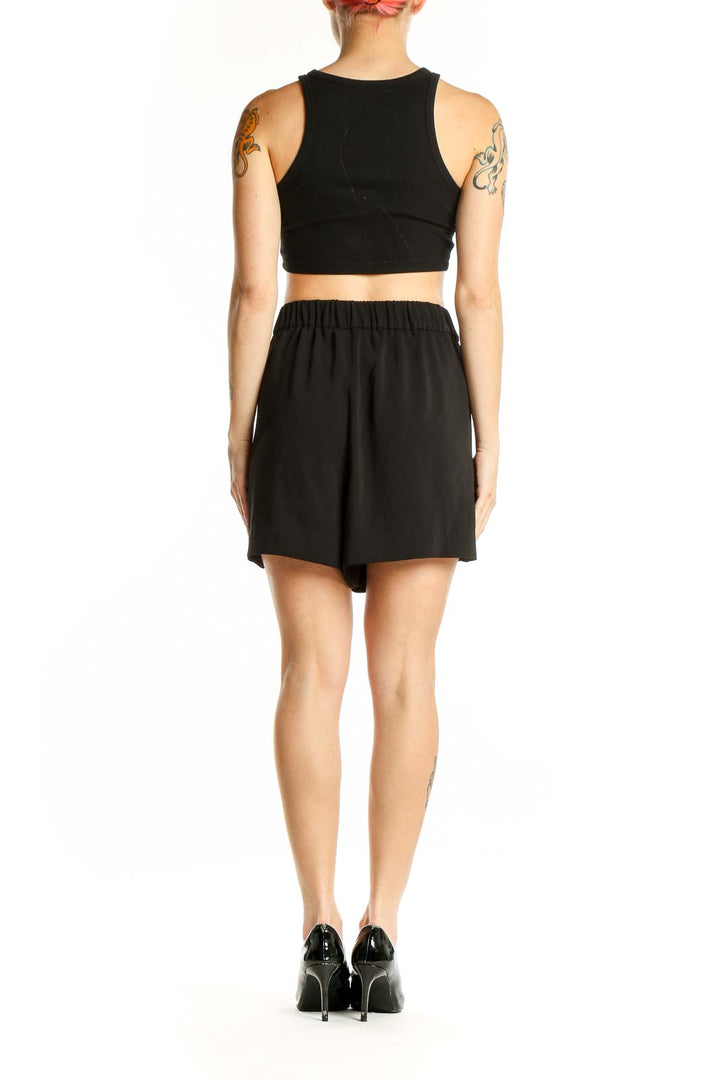 Side view of woman wearing black Calvin Klein shorts with crop top