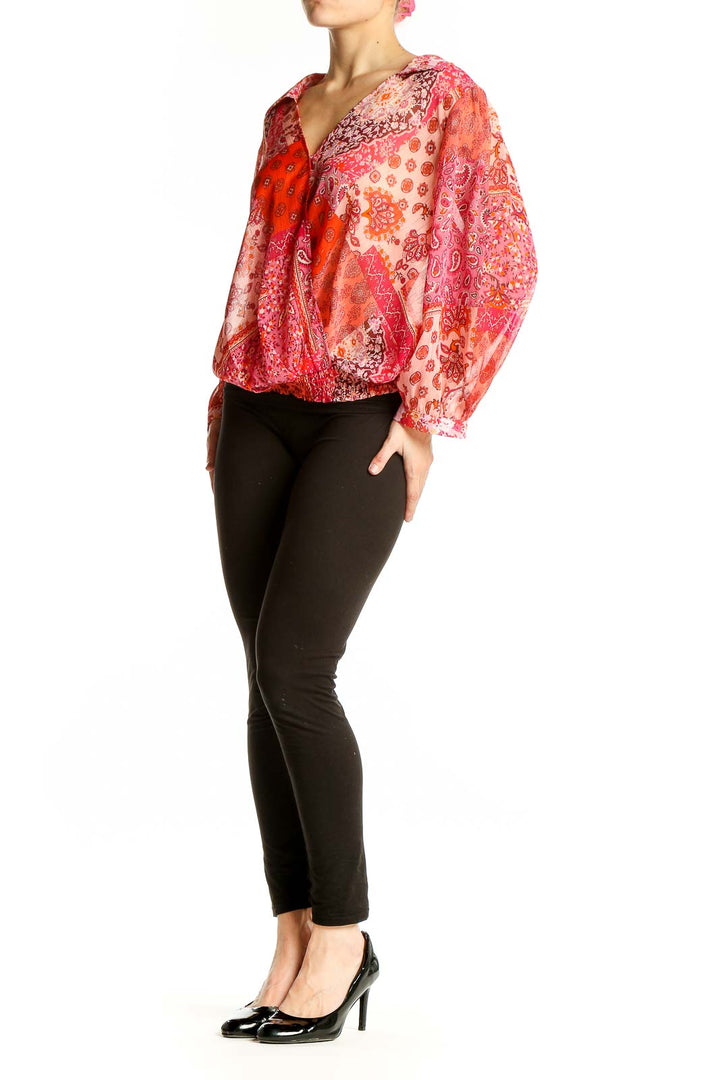 Front view of orange floral paisley wrap blouse with long sleeves