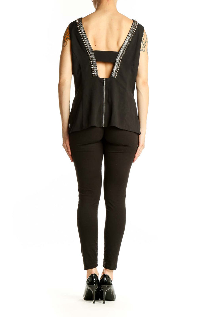 Side view of XOXO black sleeveless blouse showing fit and length