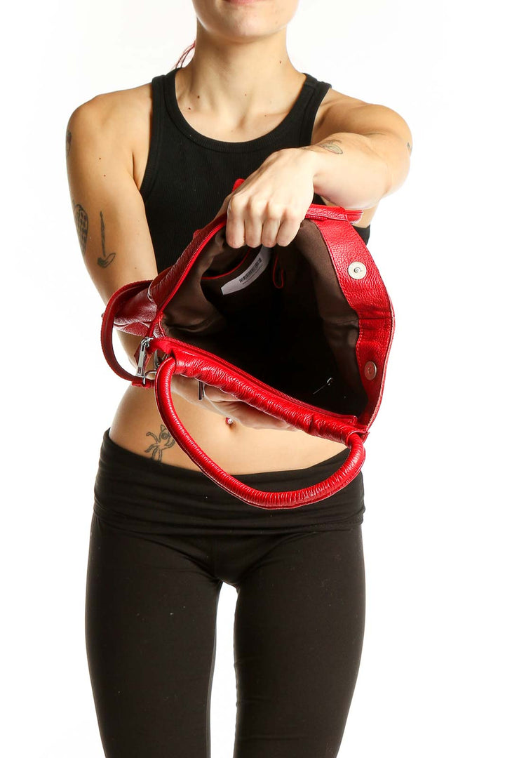 Side view of red leather crossbody shoulder bag worn by model
