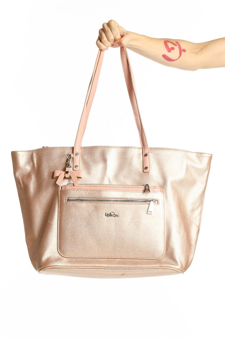 Front view of Kipling rose gold metallic tote bag with monkey keychain