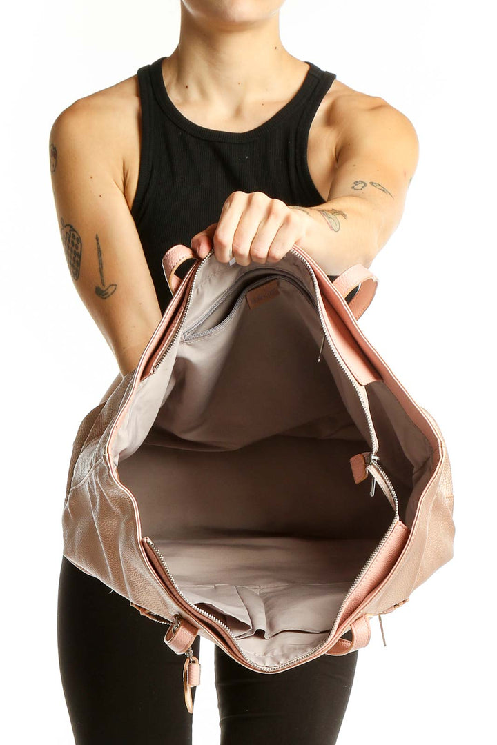 Side view of Kipling rose gold metallic tote bag worn on shoulder