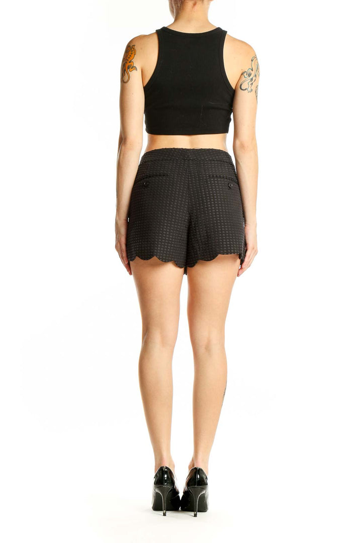 Side view of woman wearing Club Monaco black textured shorts with crop top