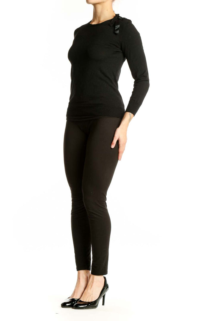Front view of black Theory sweater with ribbon shoulder detail