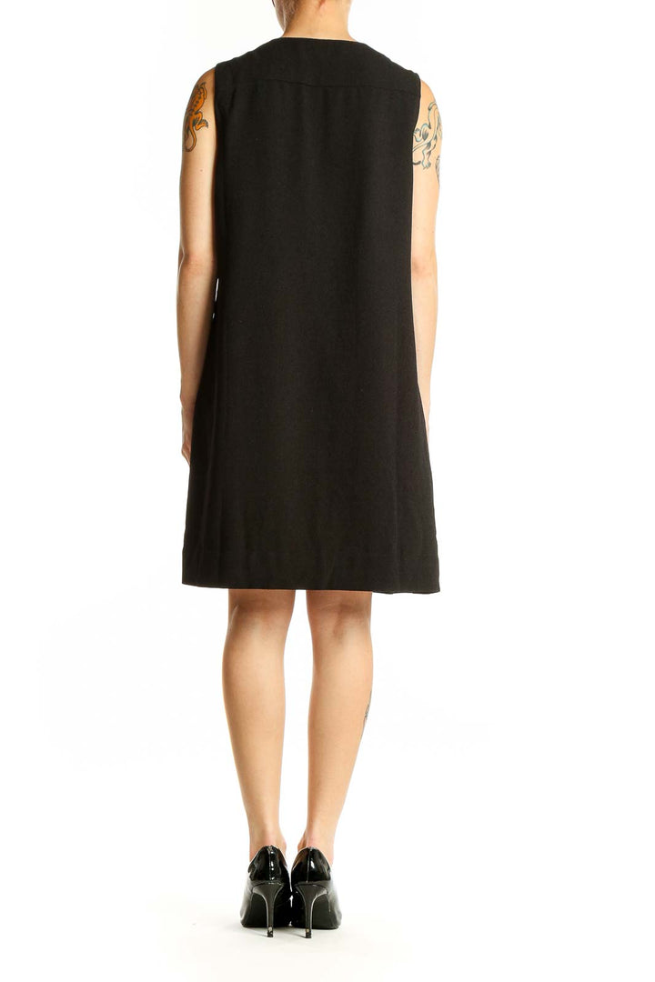 Side view of English Factory black sleeveless shift dress showing relaxed fit