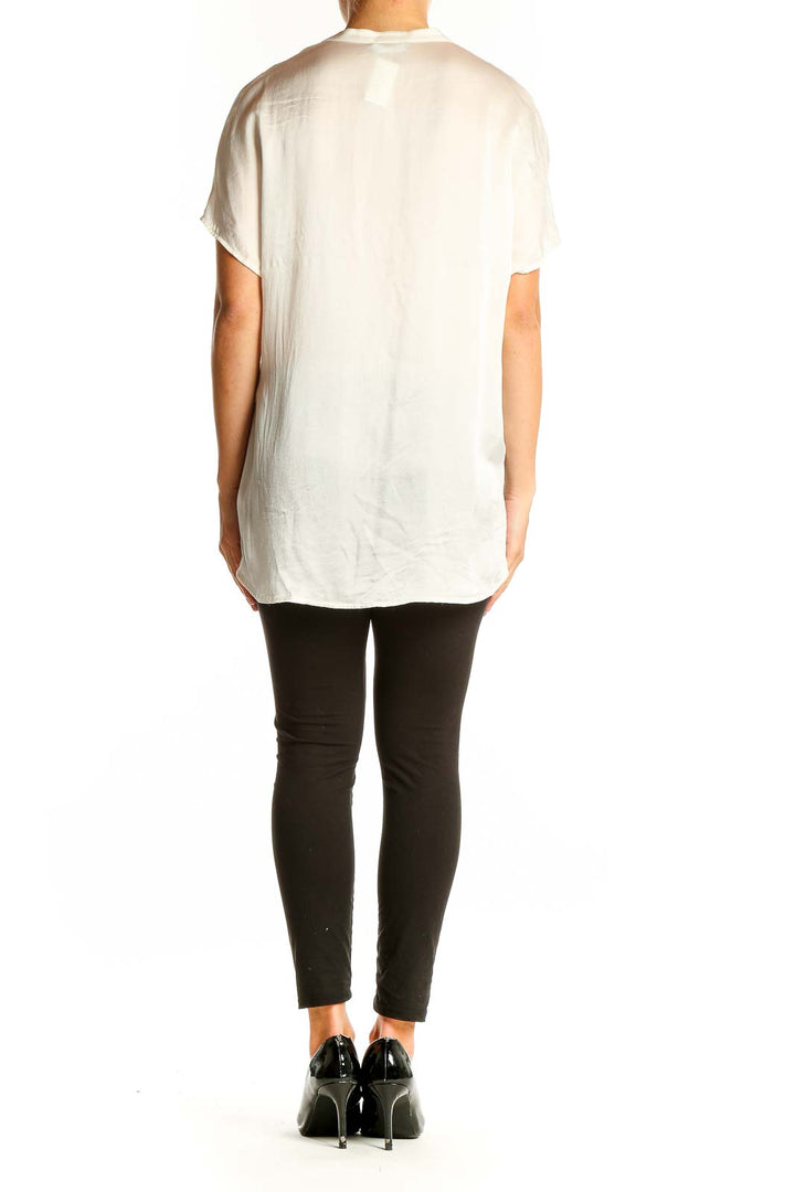 Side view of model wearing Vince white silk blouse with black pants