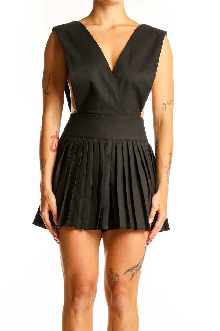 Front view of black pleated sleeveless romper with V-neckline