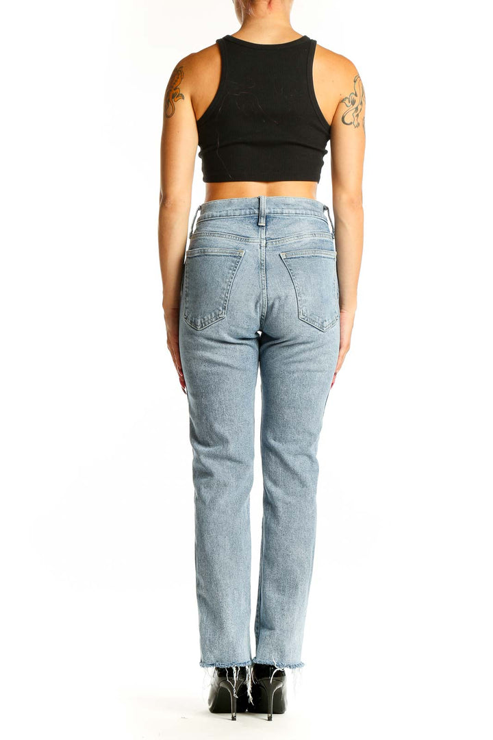 Back view of Mother light blue distressed straight leg jeans on model