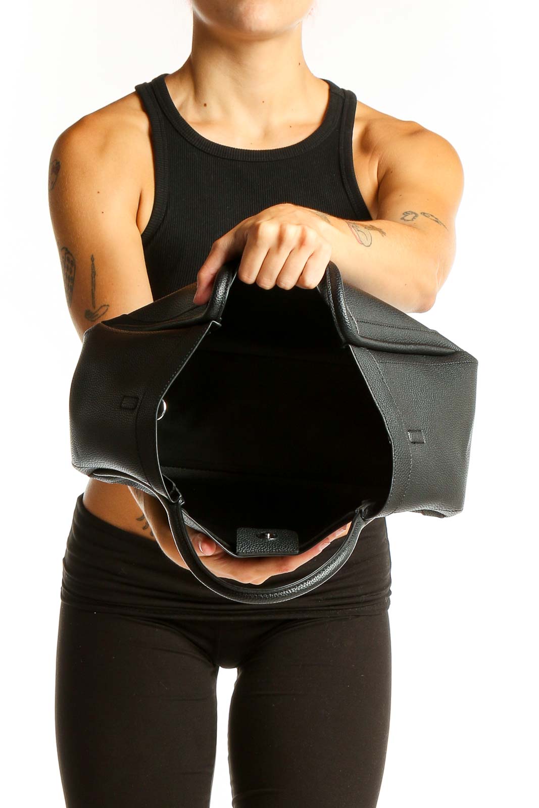 Model wearing black NEWBELLA leather shoulder bag with all-black outfit