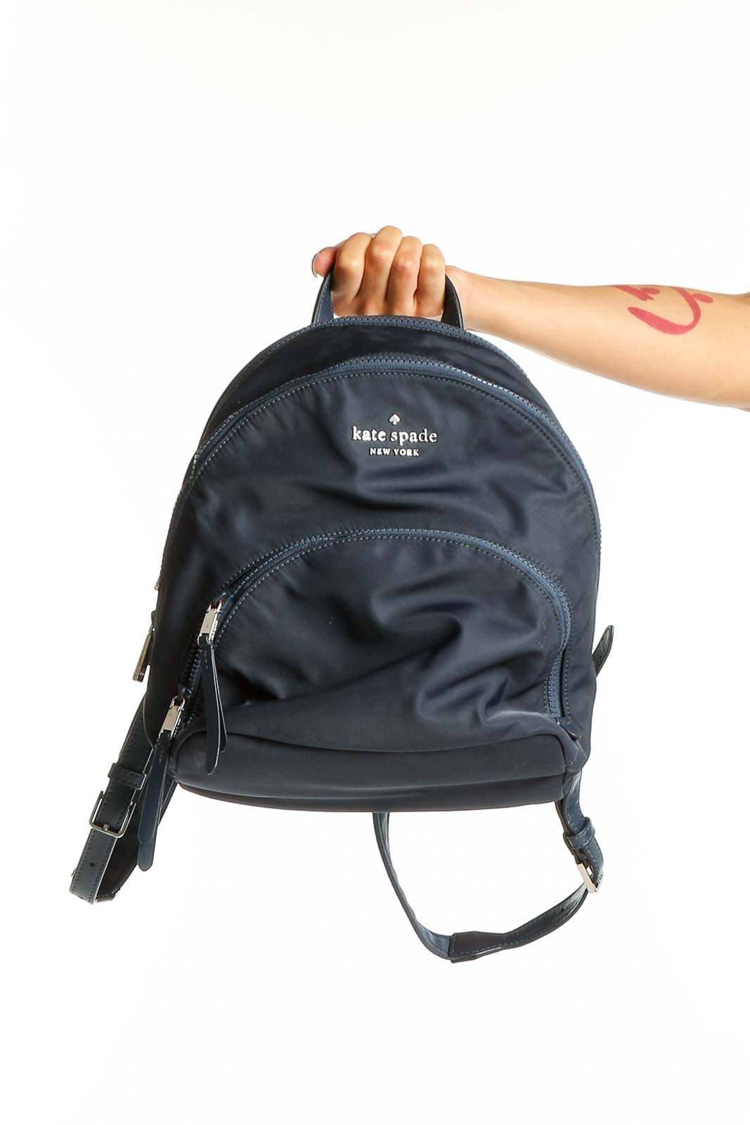 Front view of Kate Spade navy nylon backpack with logo and front zip pocket