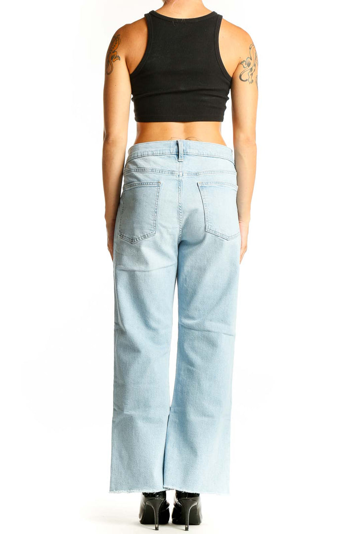 Side view of woman wearing Gap light blue wide-leg jeans with black crop top