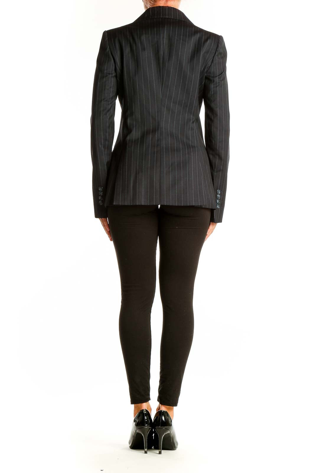 Side view of woman wearing Massimo Dutti black pinstriped blazer with black pants