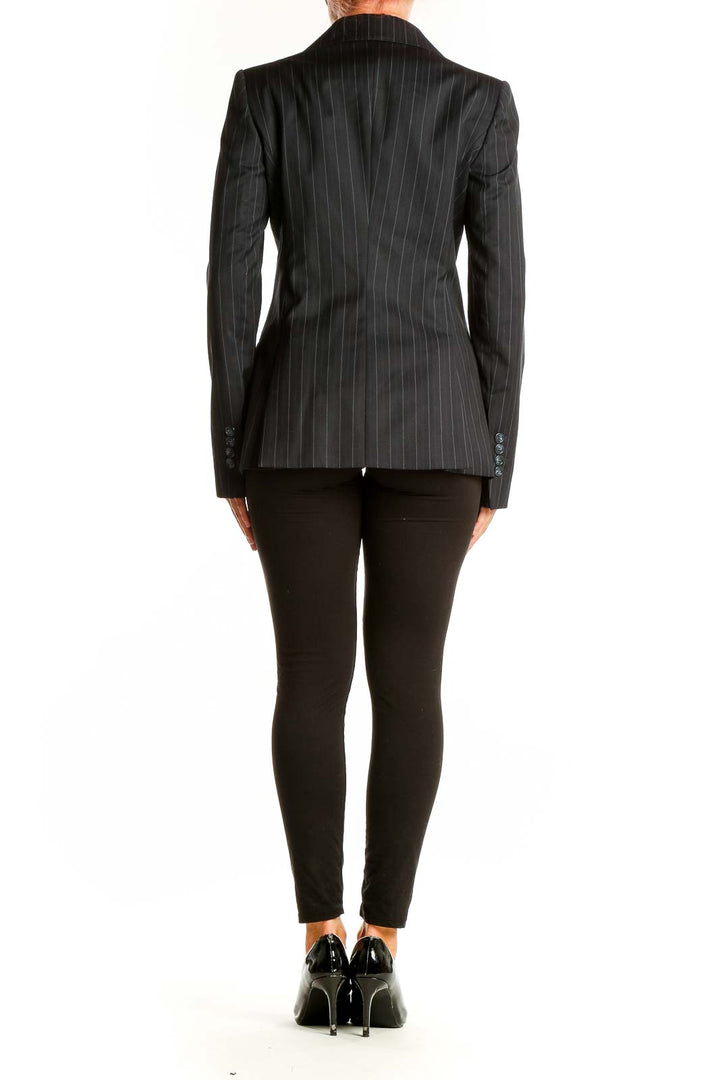 Side view of woman wearing Massimo Dutti black pinstriped blazer with black pants