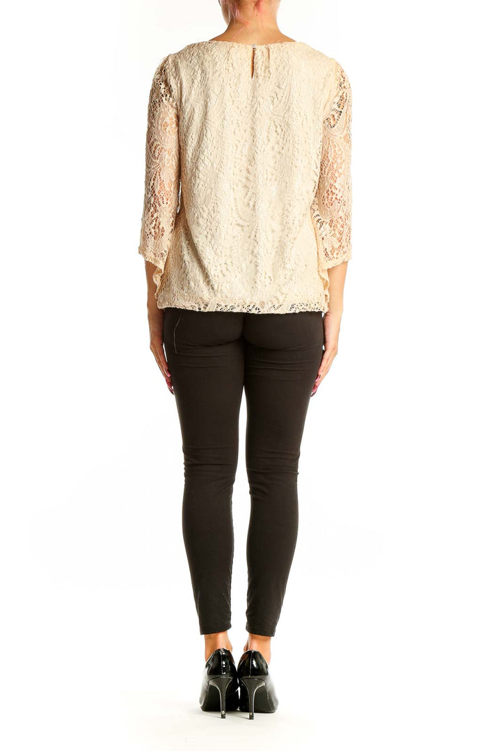 Side view of cream lace blouse showing delicate floral overlay and fit