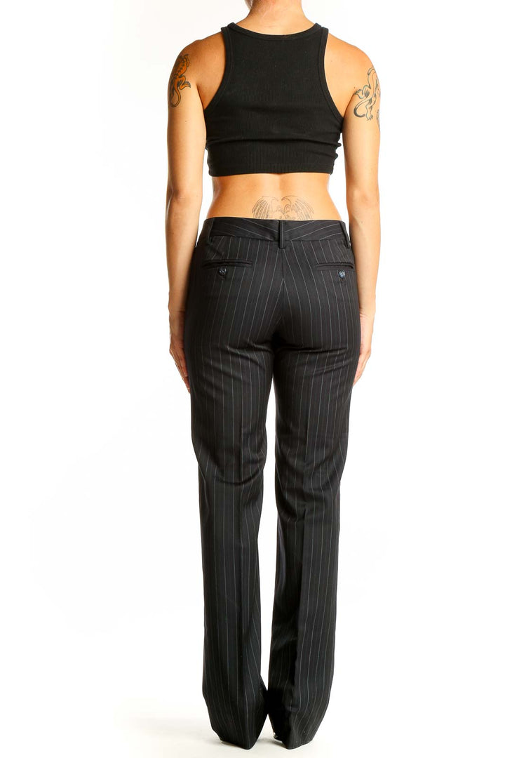 Side view of woman wearing Massimo Dutti black pinstriped wide-leg trousers