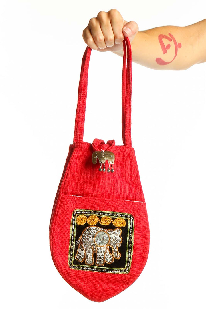 Front view of red clutch bag with embroidered elephant design