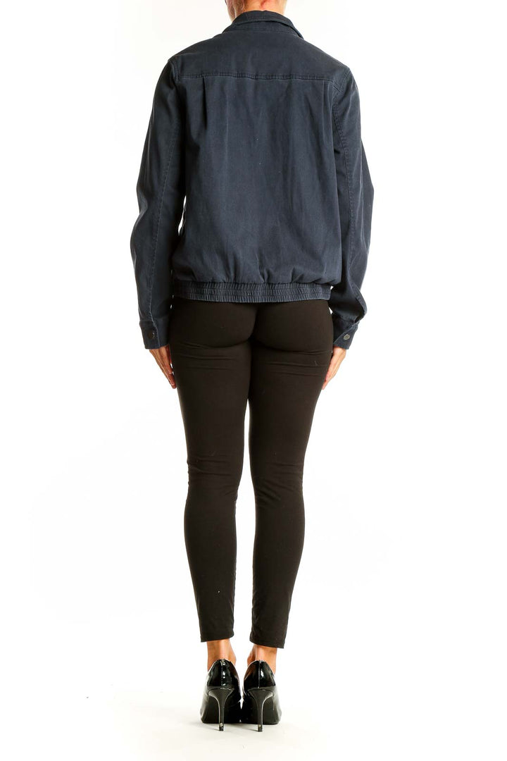 Side view of woman wearing Pendleton navy utility jacket with black pants