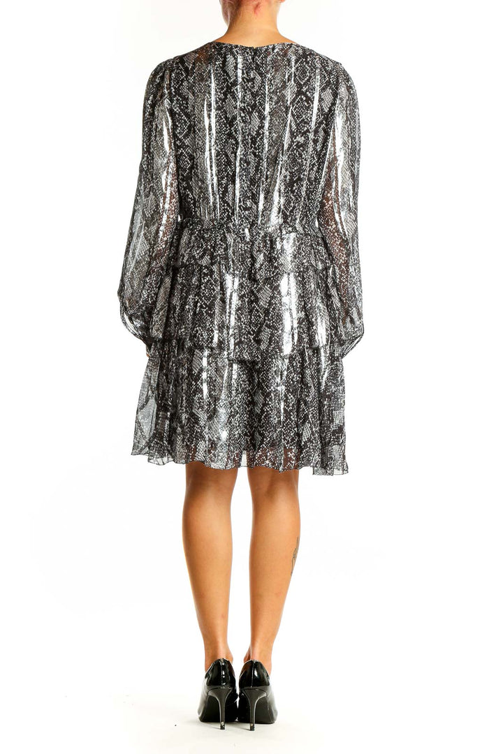 Side view of MICHAEL Michael Kors silver metallic snakeskin print cocktail dress showing long sleeves and flowing silhouette