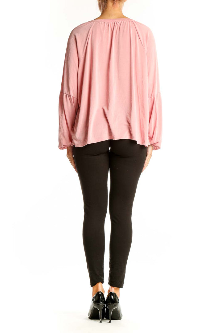 Side view of model wearing pink Lucky Brand blouse with black pants