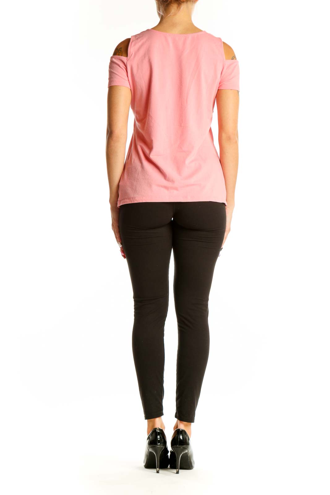 Side view of woman wearing pink MICHAEL Michael Kors cold shoulder top with black pants