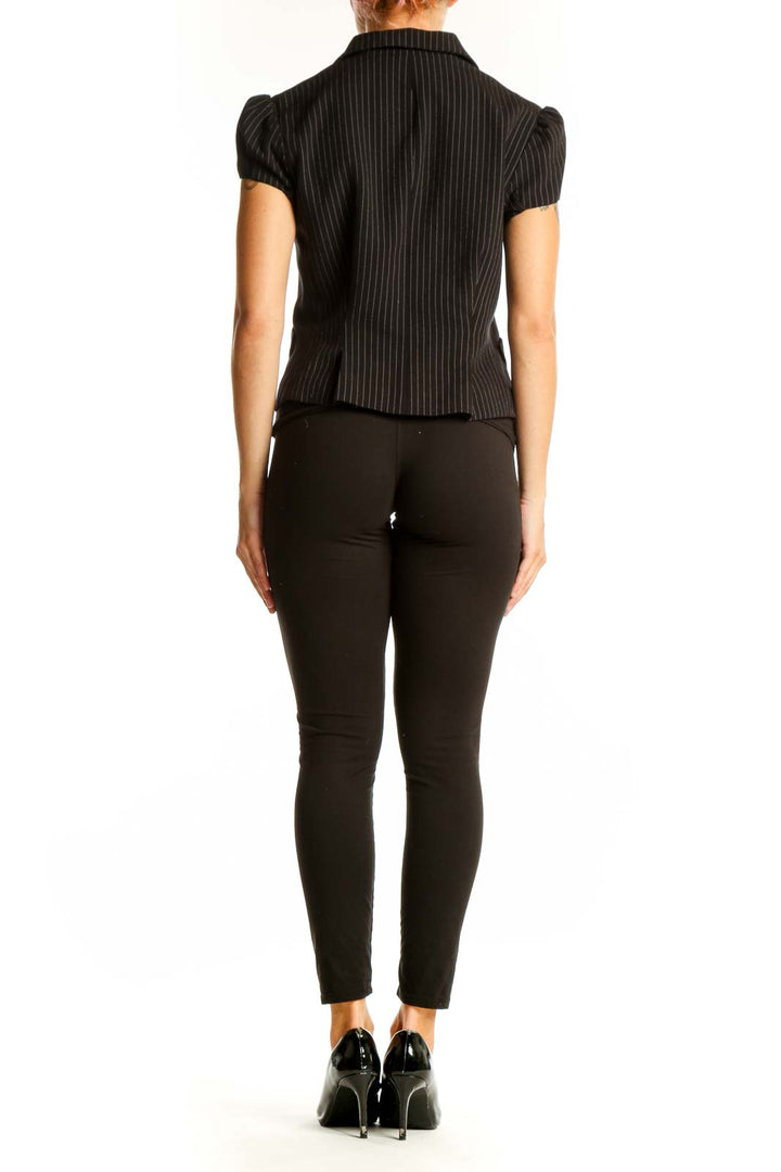 Side view of model wearing BCBG MaxAzria black pinstripe short-sleeve blazer with black pants