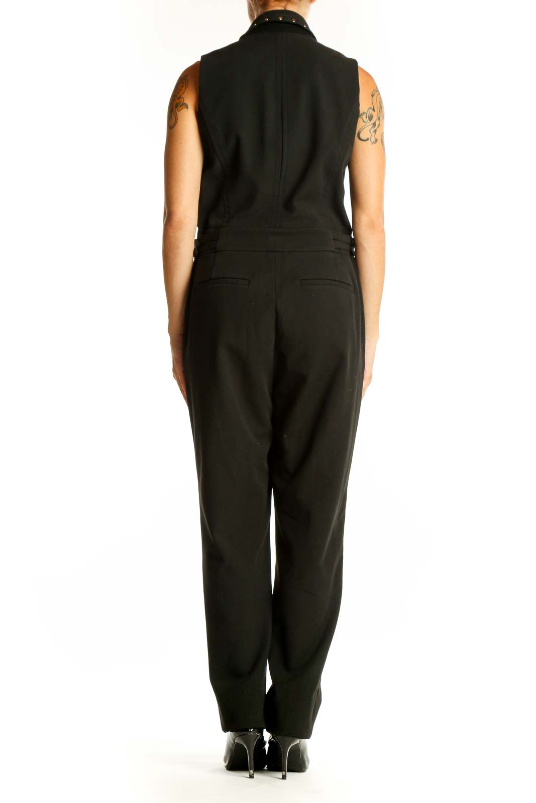 Side view of MICHAEL Michael Kors black sleeveless jumpsuit showing waist buckle details