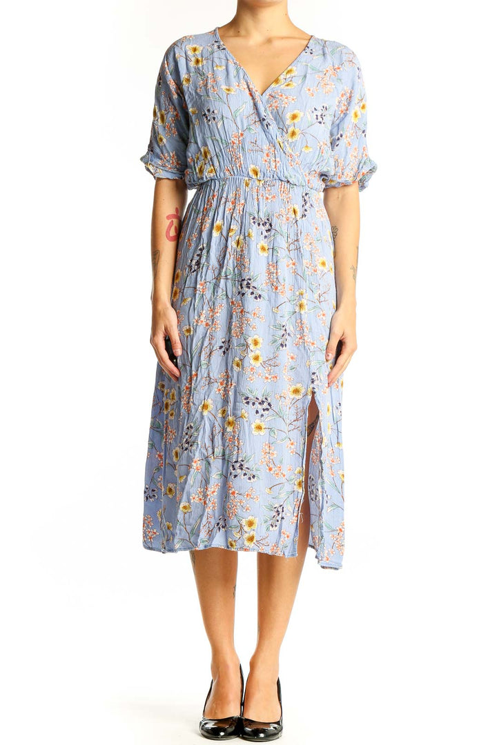Front view of All in Favor blue floral wrap midi dress with yellow and pink flowers